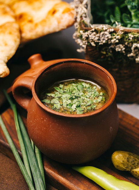 Foto gratuita sopa en cazuela de barro servida con hierbas