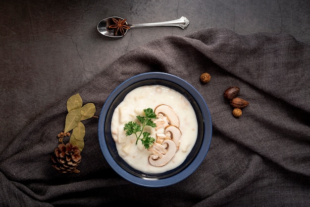 Sopa de champiñones en un frasco sobre una bufanda gris y una cuchara