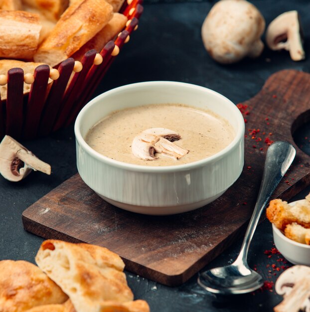 Sopa de champiñones fresca sobre la plancha de madera