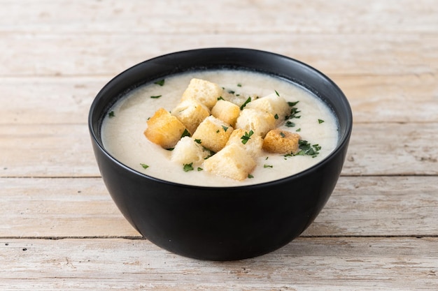 Foto gratuita sopa de coliflor en un bol sobre una mesa de madera