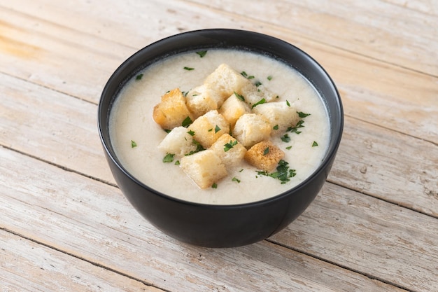 Foto gratuita sopa de coliflor en un bol sobre una mesa de madera