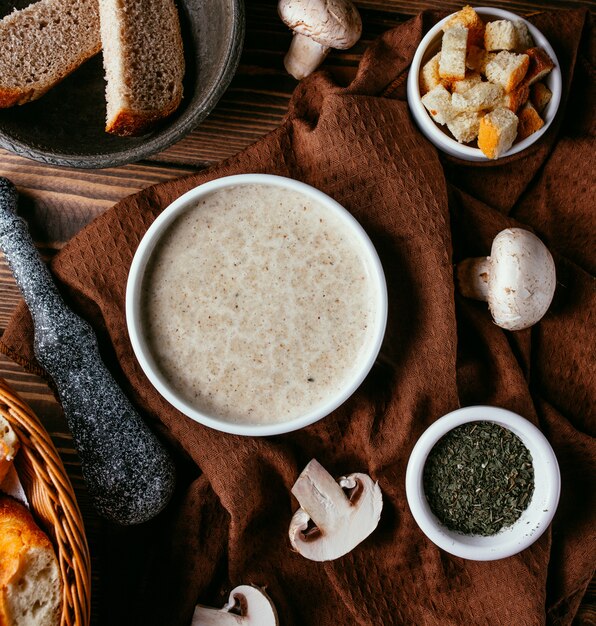 Sopa crema de champiñones con galletas vista superior sobre la mesa