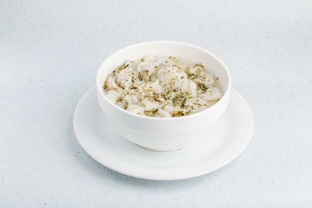 Sopa cremosa de champiñones con especias dentro de un tazón blanco.