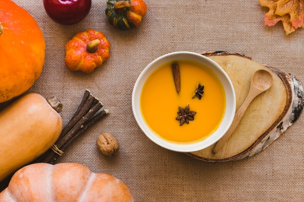 Sopa y cuchara cerca de las calabazas