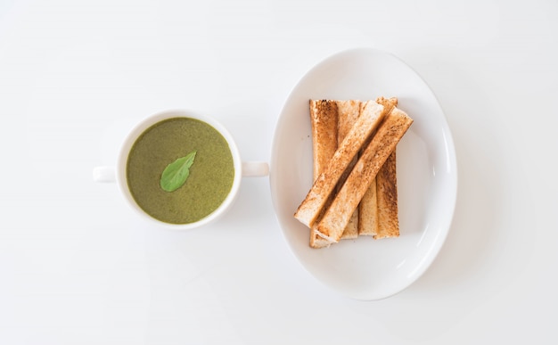 Sopa de espinacas con hojas de espinaca y pan