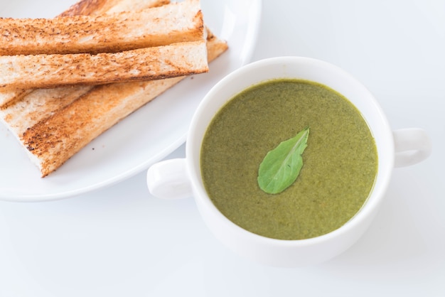 Sopa de espinacas con hojas de espinaca y pan