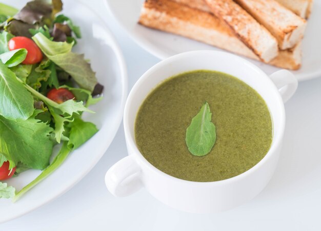 Sopa de espinacas con hojas de espinaca y pan