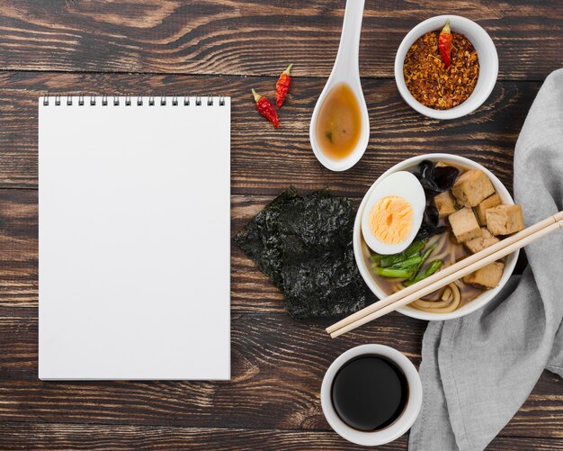 Sopa de fideos ramen asiáticos y bloc de notas