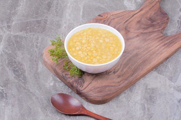 Sopa de frijoles amarillos en un plato blanco sobre la plancha de madera