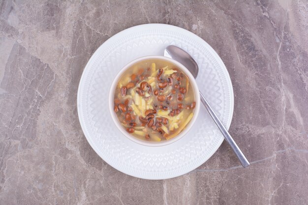 Sopa con frijoles y espaguetis en una taza de cerámica blanca