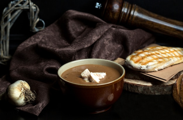 Sopa de guisantes negros con trozos de pollo servidos en un tazón