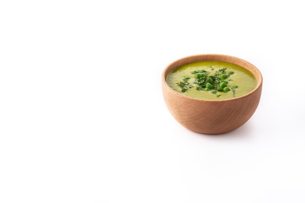 Sopa de guisantes verdes en un recipiente aislado sobre fondo blanco.