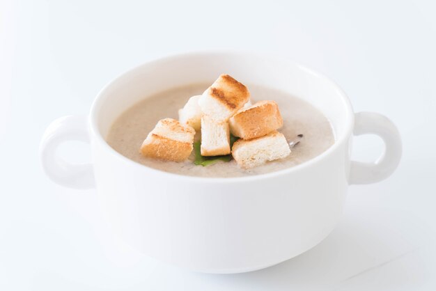 Sopa de hongos y pan en taza de cerámica blanca