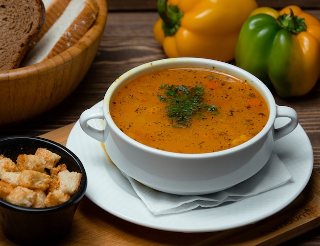 Sopa de lentejas con hierbas picadas y galletas.