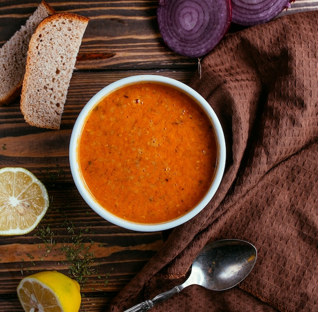 Sopa de lentejas con una rodaja de limón vista superior sobre una mesa