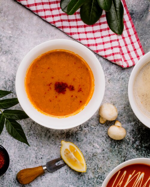 Sopa de lentejas servida con limón y champiñones sobre la mesa