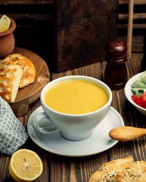 Sopa de lentejas en una taza y limón
