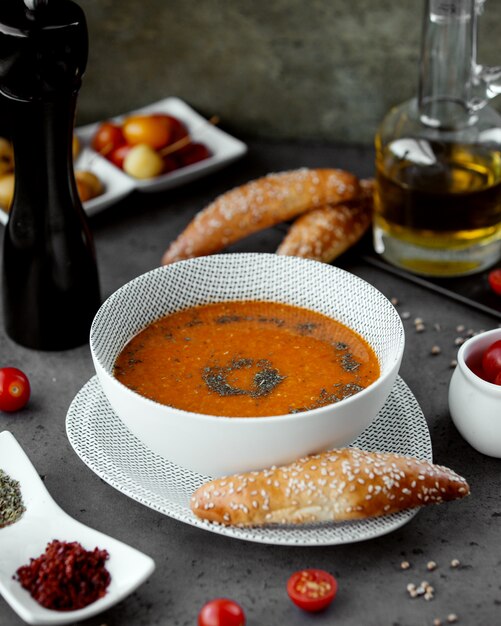 Sopa de lentejas en un tazón blanco espolvoreado con pimienta molida