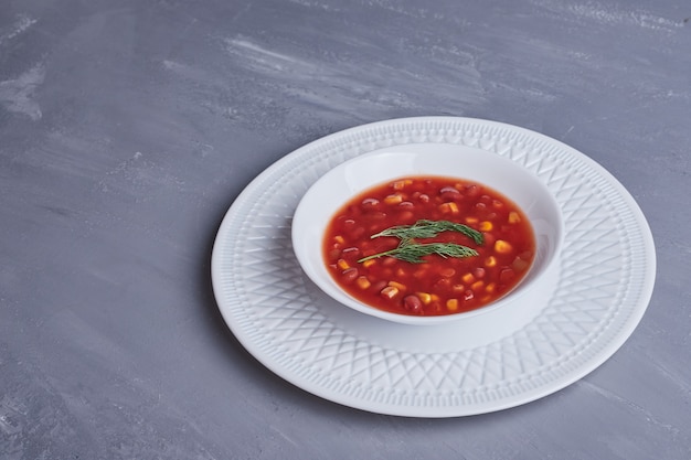 Sopa de maíz en salsa de tomate en un plato blanco.