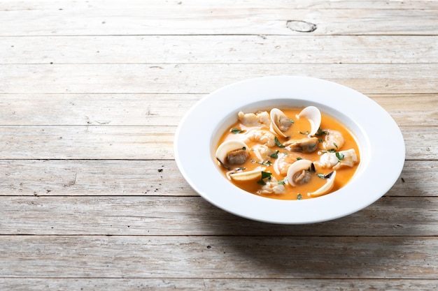 Sopa de mariscos sobre mesa de madera