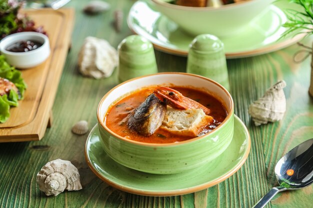 Sopa de mariscos en tazón verde