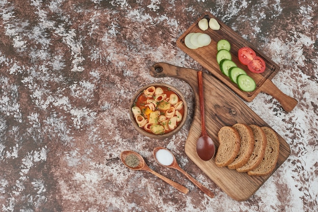 Sopa de pasta con un plato de verduras alrededor