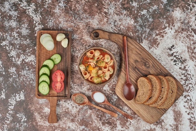 Sopa de pasta en salsa de tomate con ensalada de verduras.