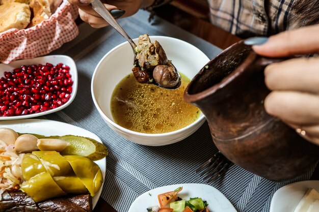 Sopa piti tradicional con carne de cordero y verduras y aperitivos vista superior