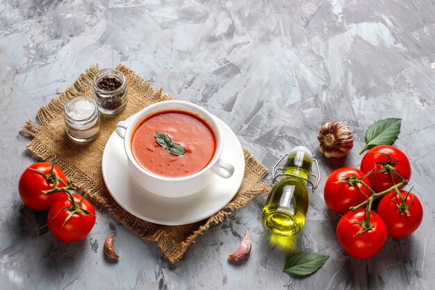 Sopa de tomate con albahaca en un bol.