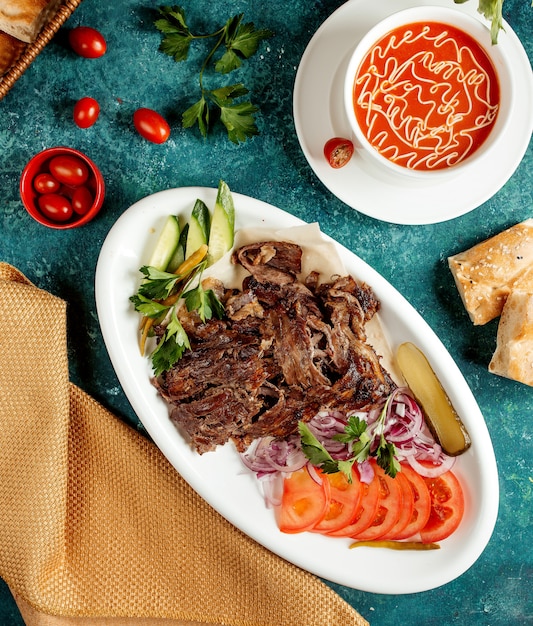 Sopa de tomate y carne frita con cebolla, tomate y pepino.