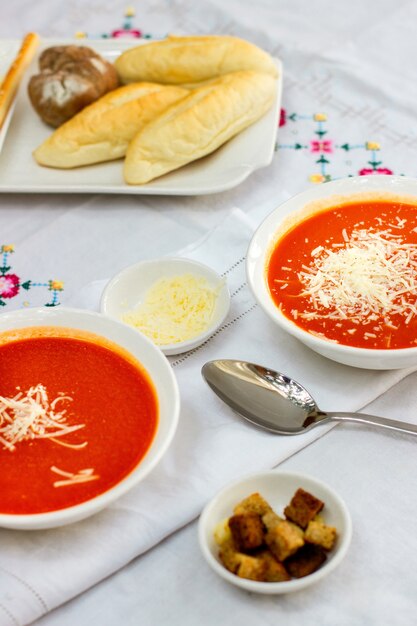 Sopa de tomate con galletas y queso rallado.