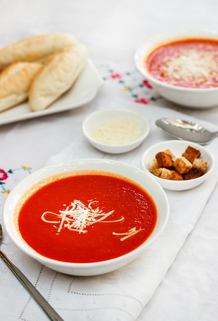 Sopa de tomate con galletas y queso rallado.