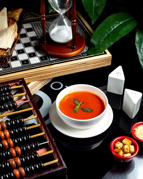 Sopa de tomate con queso y galletas saladas.