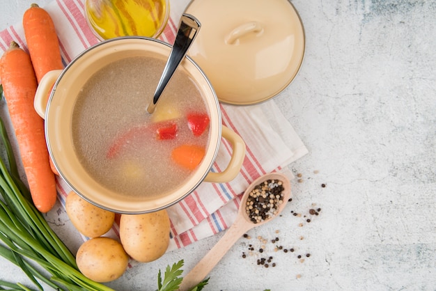 Sopa de verduras en olla e ingredientes naturales.