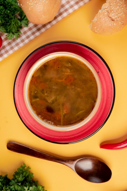 Foto gratuita sopa de verduras pan y cuchara de madera