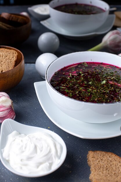 Sopa de verduras rojas Borsh con pan y crema agria en el escritorio gris