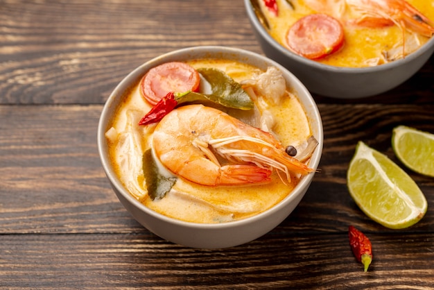 Sopas de alto ángulo en tazones con camarones y limón.