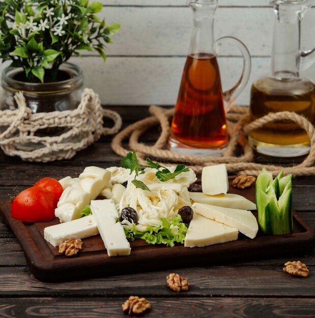 Soporte de madera con quesos en rodajas de diferentes tipos sobre la mesa