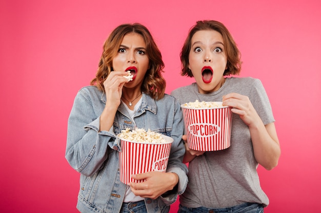 Sorprendidas amigas comiendo palomitas ver película