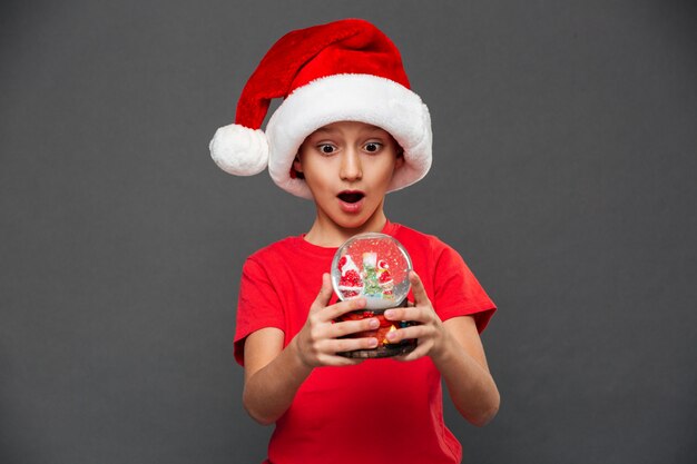 Sorprendido niño niño con sombrero de navidad santa