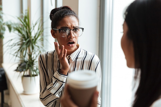 Sorprendidos asustadas empresarias colegas hablando