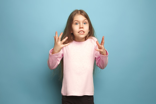 sorpresa, deleite, alegría, alegría, victoria, éxito y suerte. chica adolescente sorprendida sobre un fondo azul de estudio. Expresiones faciales y concepto de emociones de personas.