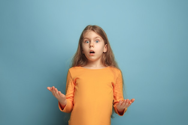 La sorpresa, el deleite. La chica adolescente sorprendida en un estudio azul.