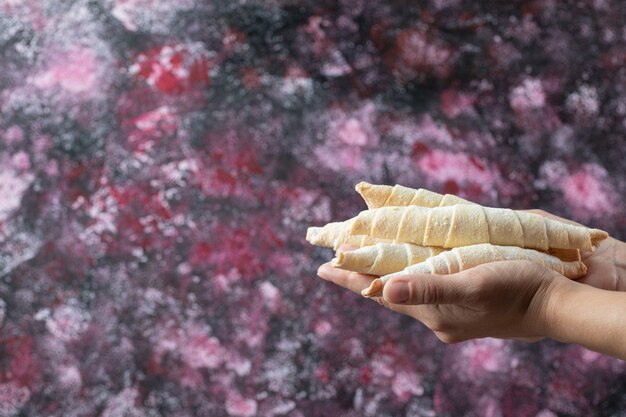 Sosteniendo galletas de mantequilla crujientes en la mano.