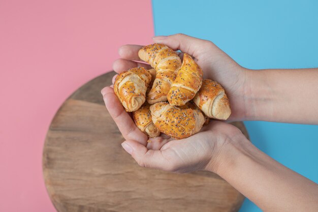 Sosteniendo galletas de mini croissant en la mano.