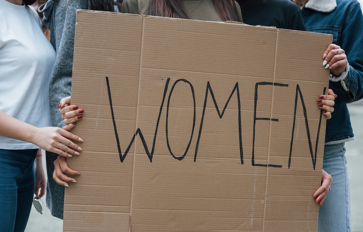 Foto gratuito sosteniendo gran cartel. grupo de mujeres feministas al aire libre protesta por sus derechos