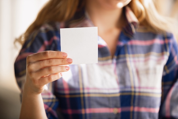 Sosteniendo hojas vacías. cerca de manos femeninas caucásicas, trabajando en la oficina. concepto de negocio, finanzas, trabajo, compras en línea o ventas. copyspace. freelance en educación, comunicación.