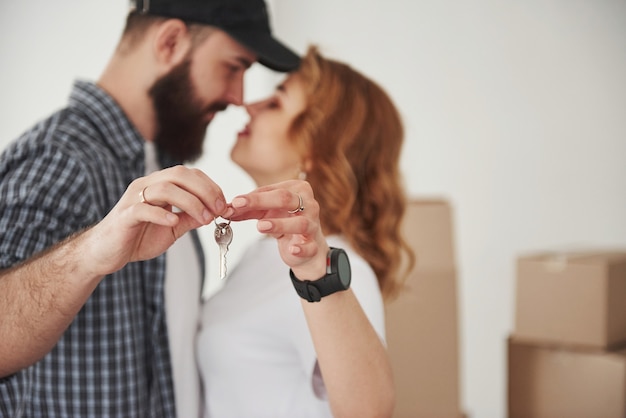 Sosteniendo las llaves juntas. Pareja feliz juntos en su nueva casa. Concepción de mudanza