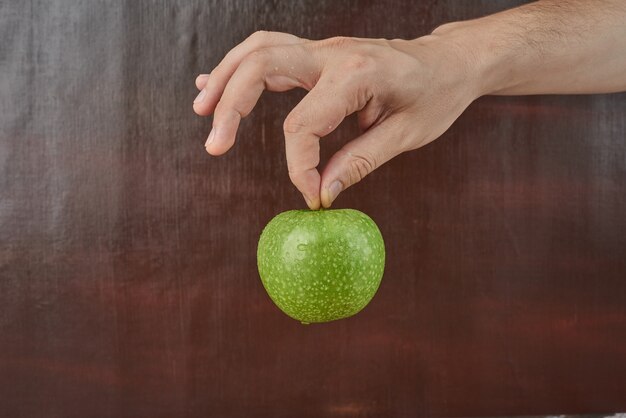 Sosteniendo la manzana en la mano