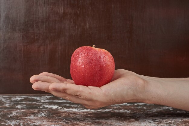 Sosteniendo la manzana en la mano